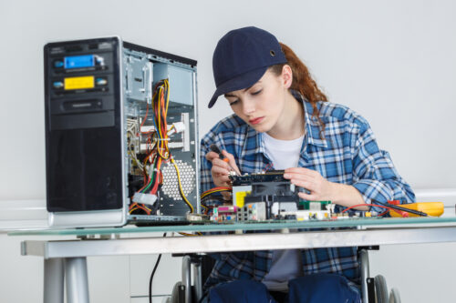 a woman in a wheelchair working on a computer