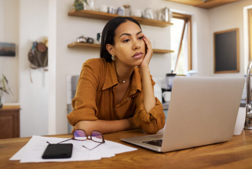 a woman sitting at a table with her hand on her face