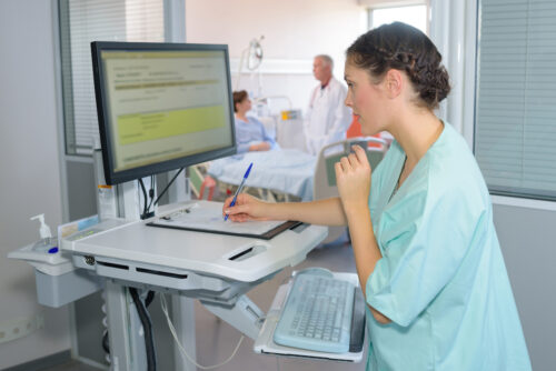 a woman in a hospital gown writing on a clipboard