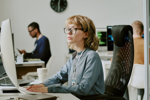 a woman sitting at a desk with a computer