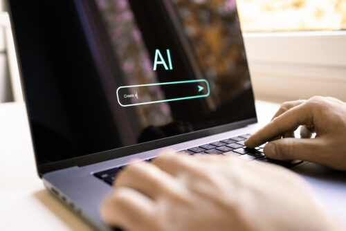 Person typing on laptop with AI