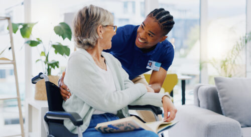 Caregiver assisting elderly woman in wheelchair