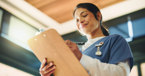 Smiling nurse with clipboard in hand