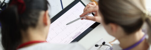 Doctors studying electrocardiogram on digital tablet closeup. Medical education concept