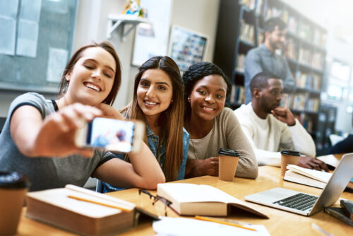 Women friends, selfie and college library with smile, happiness or diversity for social media app. Girl, group and happy for photography, profile picture or blog for solidarity, education or support